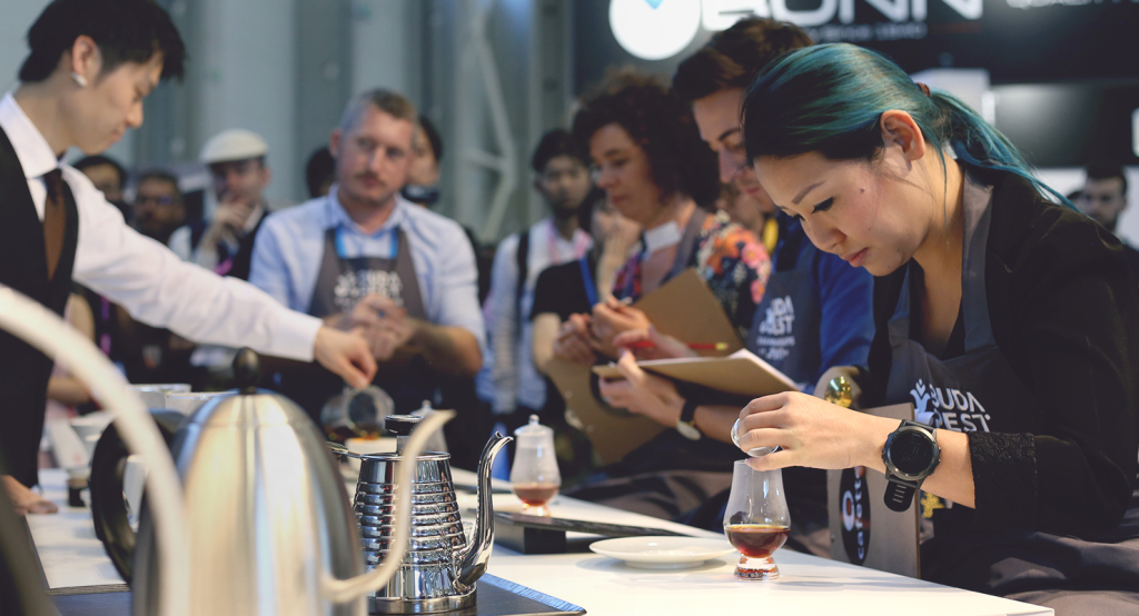 A judge removes the snifter lid during the performance from Yasuhito Kobayashi of Ogawa Coffee in Japan